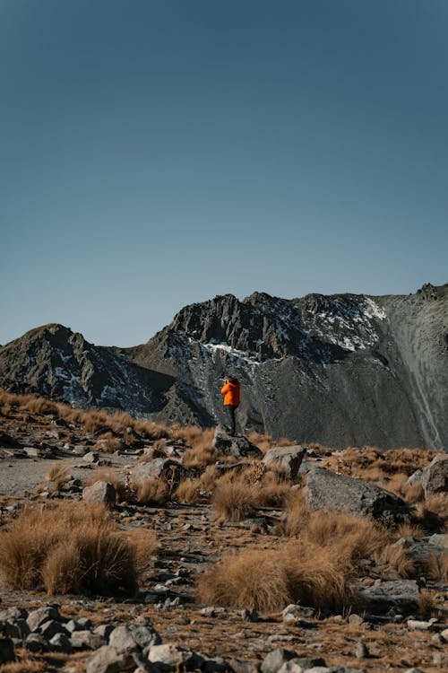 Man hiking through a rugged mountain landscape, embracing mindful outdoor recovery.