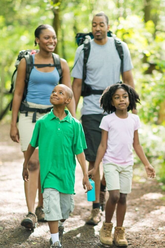 amily enjoying a peaceful walk through the forest as part of their unplugging routine, embracing screen-free time and meaningful outdoor connection.