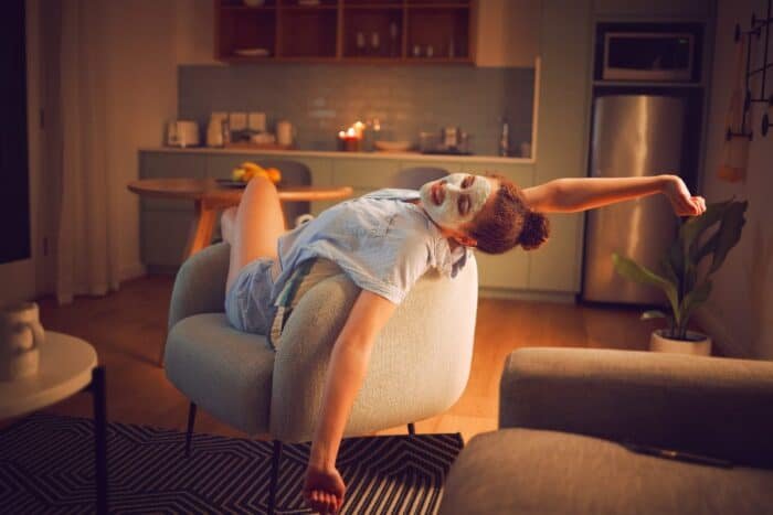 Blog A cozy living room with warm lighting, a person relaxing with a book and no devices in sight, representing an ideal evening unplugging routine.