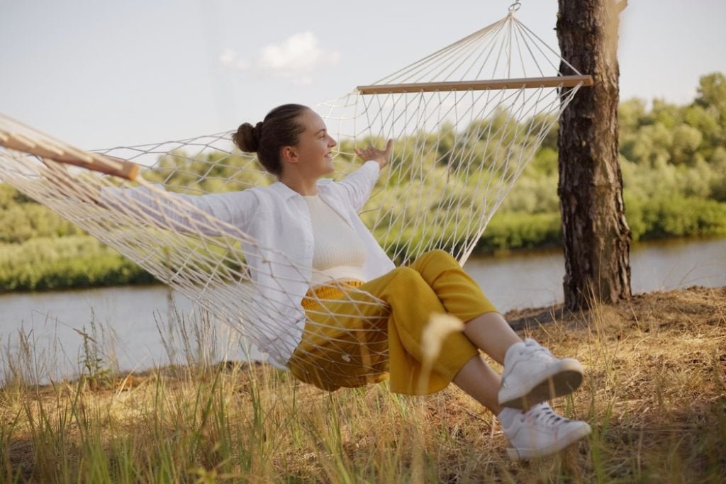 Blog A person peacefully relaxing in a hammock outdoorsâperfect for representing the calm and reset period during a detox evening .