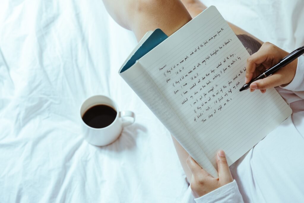 Hands writing in a journal beside a steaming cup of coffee—capturing a peaceful journaling  for unplugging ritual in a distracted world.