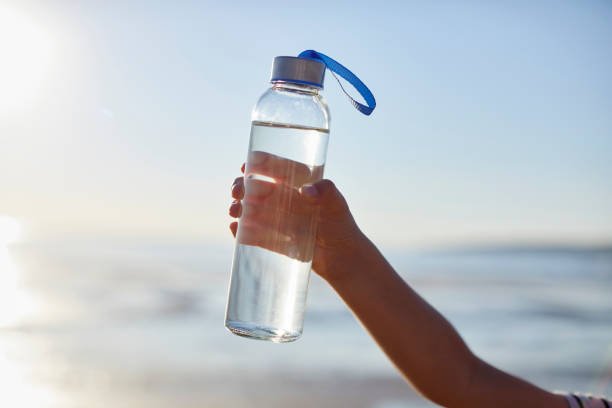 11 Easy Steps for Transitioning to a Plastic-Free Lifestyle Clean Drinking Water In Glass Bottle Held By Boy