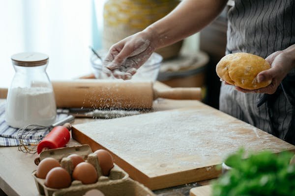 7 Powerful Ways to Track Your Carbon Footprint at Home and Make a Real Impact "Person sprinkling flour on a cutting board in a home kitchen, symbolizing thoughtful home practices and mindful routines."