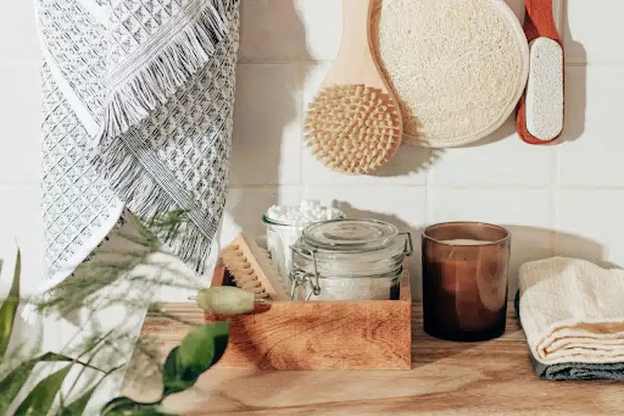 Blog "Flat lay of eco-friendly lifestyle items including reusable cloths, wooden dish brushes, and glass containers arranged on a neutral background — promoting sustainable living practices for busy individuals."