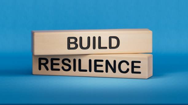 Wooden blocks stacked on a blue background spell out "BUILD RESILIENCE".