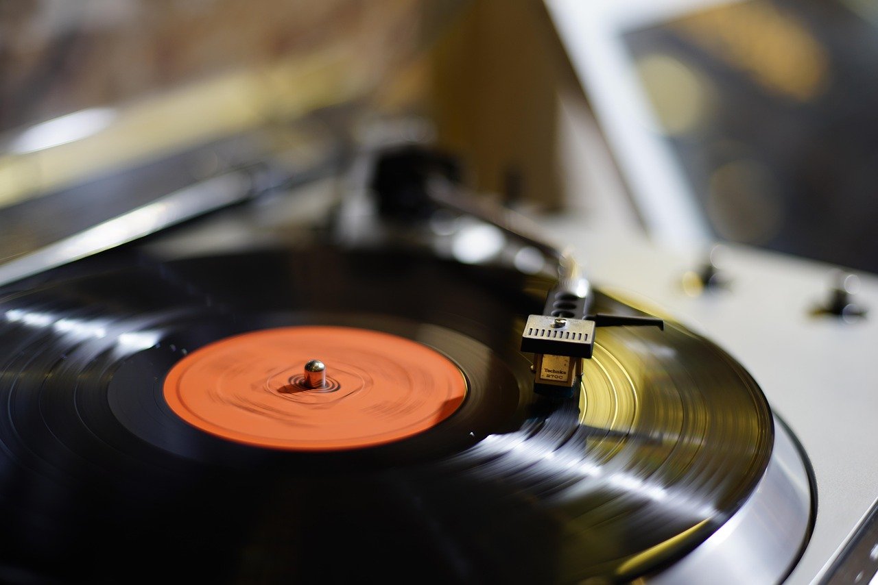 Find Your Calm in 10 Minutes: Simple Mindfulness Practices for a Busy Life A young woman with headphones on, listening to a music player while sitting in a field of flowers.