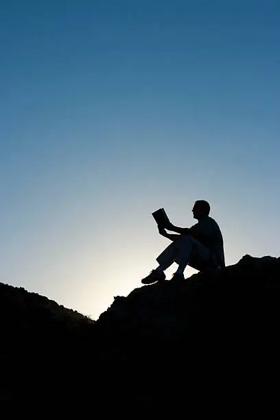 silhouette of man reading