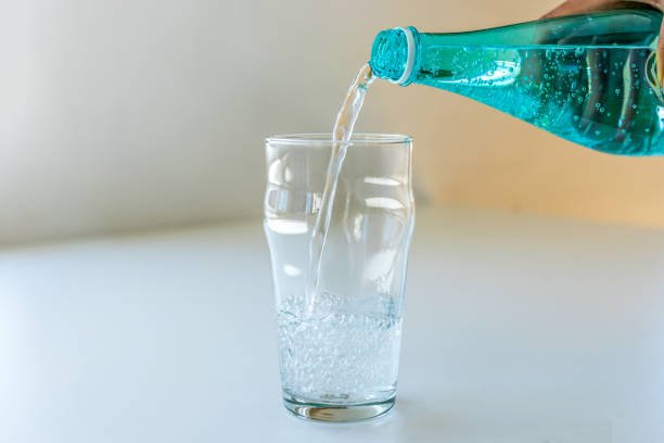 7 Thrilling Sustainable Living Challenges to Try This Month: Your Eco-Adventure Awaits! Unrecognisable Person Pouring Mineral Water