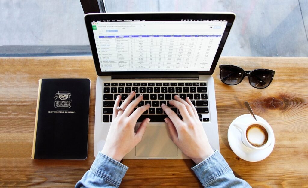 Unlock Your Productivity Power: Simple Mindfulness Techniques for Laser Focus at Work "Practicing single-tasking and mindfulness at work, a person focuses solely on their spreadsheet, with a coffee and notebook on the wooden table."