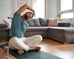 A person on an exercise mat performing Child's Pose, an essential stretch for a home warm-up and cool-down routine.